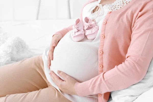 Pregnant woman holding baby shoes — Stock Photo, Image