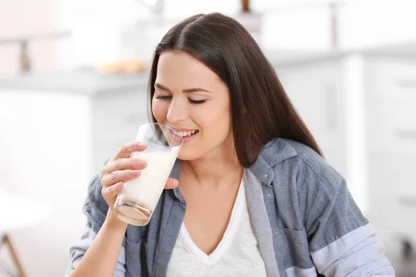 Young attractive woman drinking milk, closeup