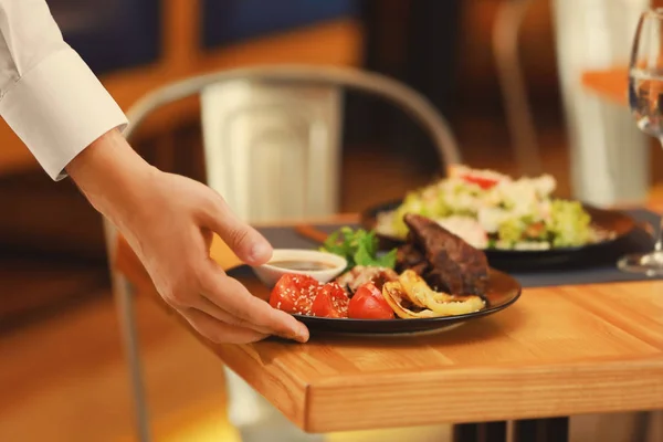 Waiter serving meals — Stock Photo, Image