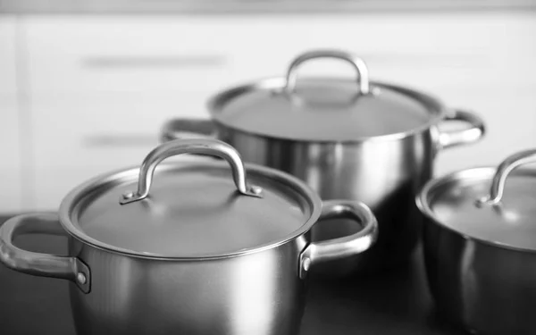 Stainless saucepans on table — Stock Photo, Image