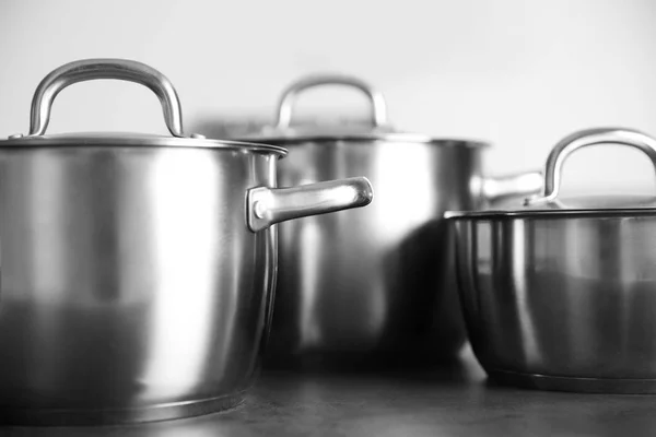 Stainless saucepans on table