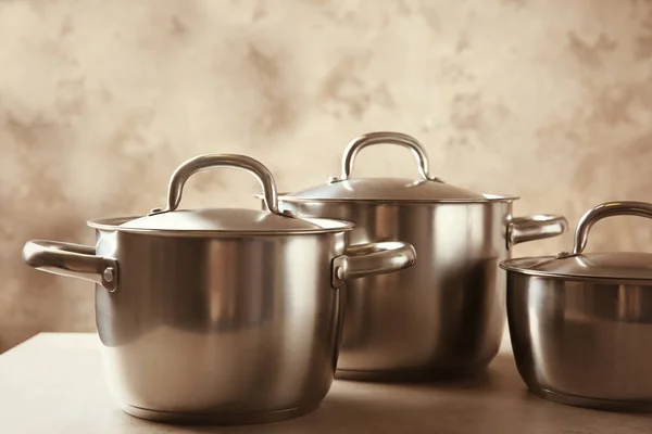 Stainless saucepans on table — Stock Photo, Image