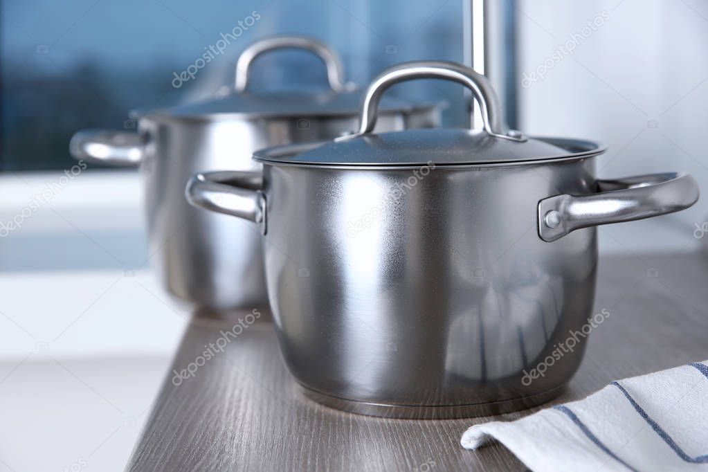 Stainless saucepans on table