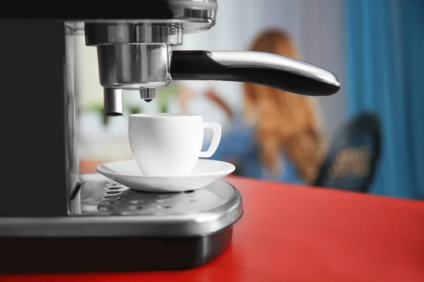 Taza de café expreso fresco y nueva cafetera en la mesa — Foto de Stock