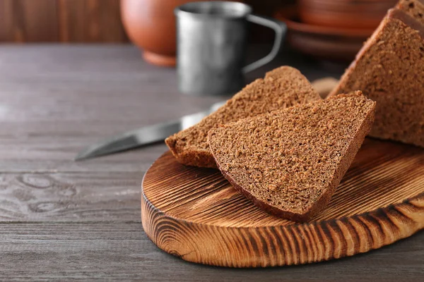 Sliced bread on wooden cutting board — Stock Photo, Image