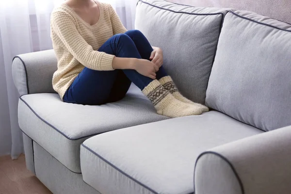 Молода дівчина сидить на дивані — стокове фото