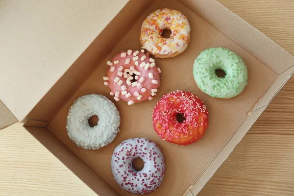 Box with tasty colorful donuts