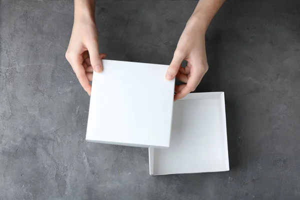 Mãos femininas abrindo caixa branca — Fotografia de Stock