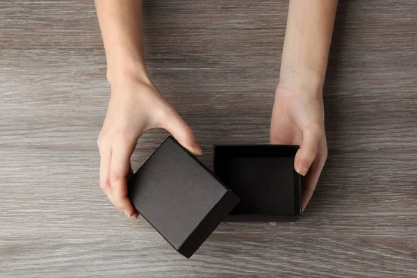 Manos femeninas abriendo caja negra — Foto de Stock