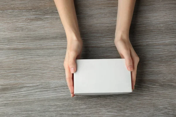 Manos femeninas con caja blanca — Foto de Stock