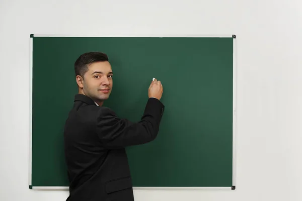 Handsome young teacher writing — Stock Photo, Image