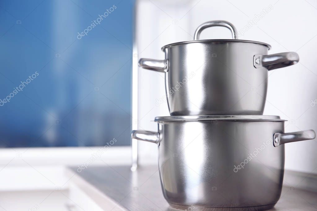 Stainless saucepans on kitchen table