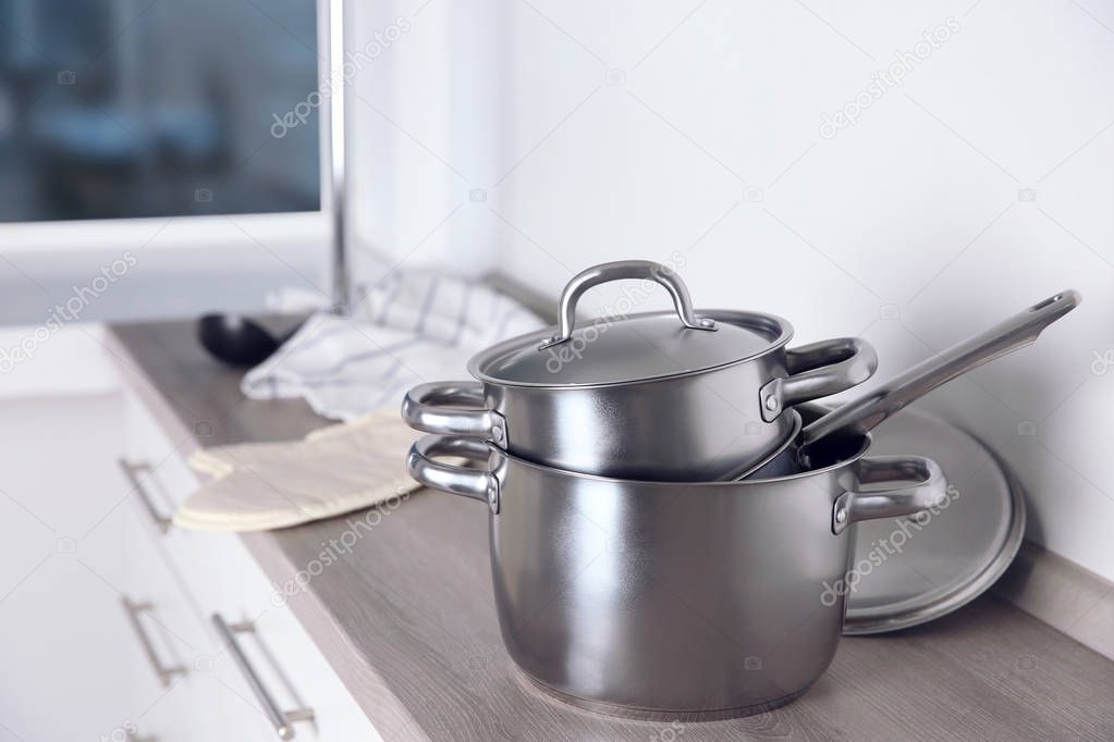 Stainless saucepans on kitchen table