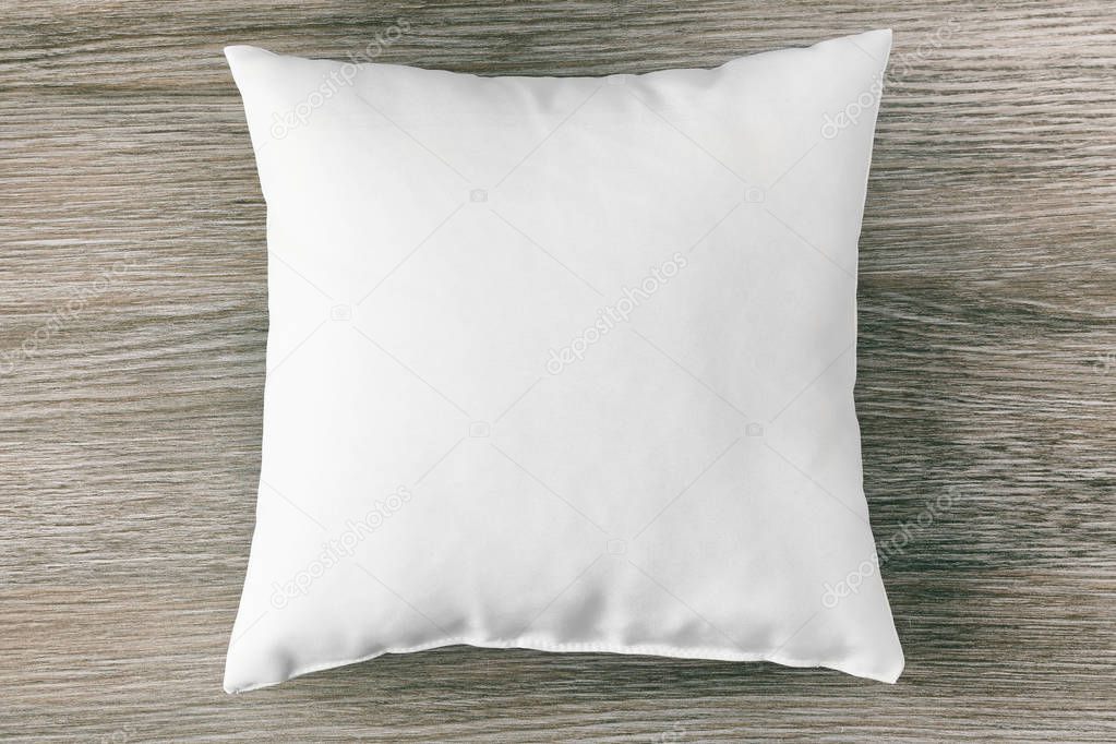 Blank soft pillow on wooden background