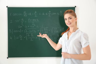 Blackboard yanında genç öğretmen  