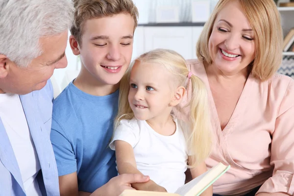 Schattige kinderen met grootouders lezen boeken in woonkamer — Stockfoto