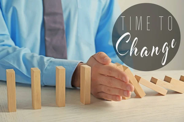 Male hand stopping falling dominoes — Stock Photo, Image