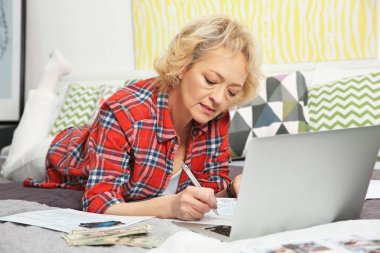 Senior woman calculating taxes  clipart