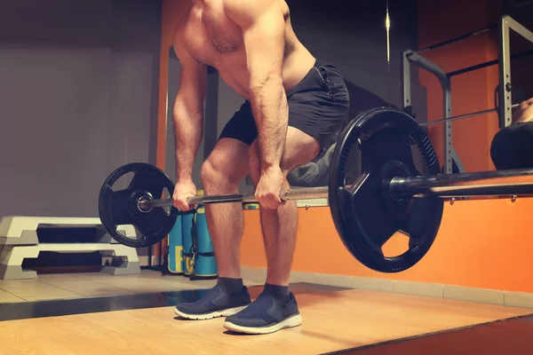 Jovem homem bonito com treinamento barbell no ginásio — Fotografia de Stock