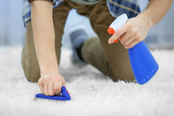 Anak muda membersihkan karpet — Stok Foto