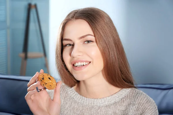 Jovem mulher comer biscoito — Fotografia de Stock