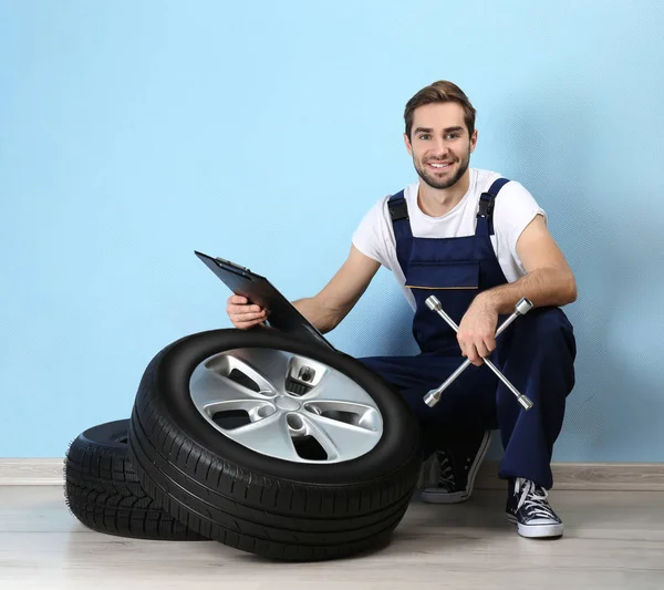 Young mechanic with wheels — Stock Photo, Image