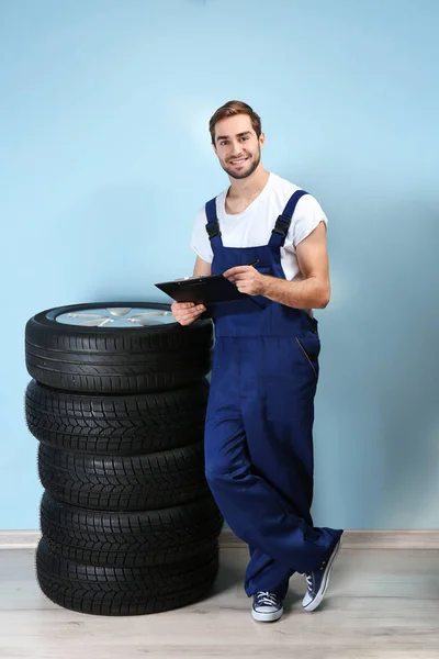 Jovem mecânico em uniforme com prancheta — Fotografia de Stock