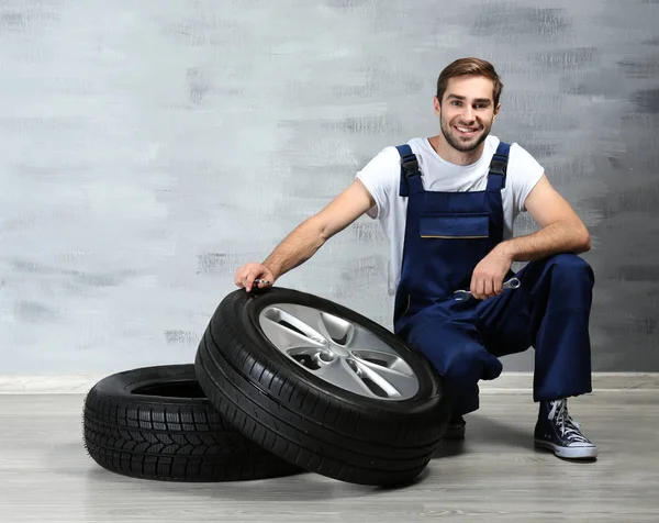 Young mechanic with wheels — Stock Photo, Image