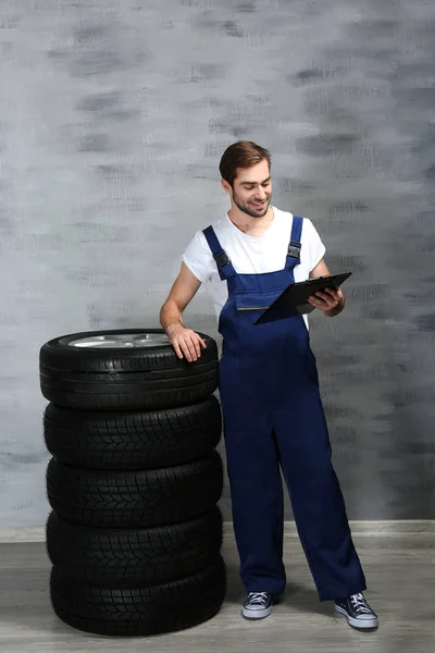 Junger Mechaniker in Uniform mit Klemmbrett — Stockfoto