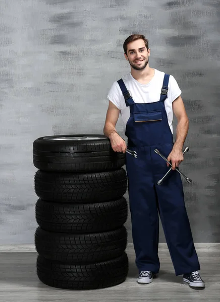 Young mechanic with wheels — Stock Photo, Image