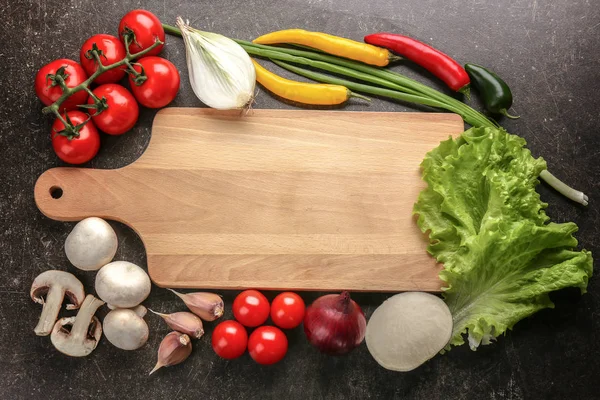 Planche à découper et légumes — Photo