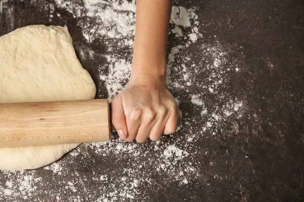 Junge Frau rollt Teig aus — Stockfoto