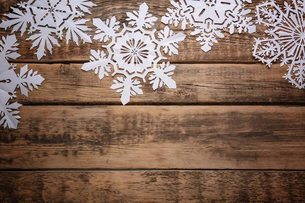 Hermosos copos de nieve de papel sobre fondo de madera —  Fotos de Stock