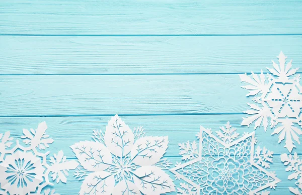 Renk ahşap arka plan üzerinde güzel kağıt kar taneleri — Stok fotoğraf