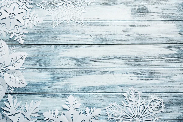 Hermosos copos de nieve de papel sobre fondo de madera —  Fotos de Stock