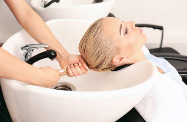Hairdresser washing woman's hair