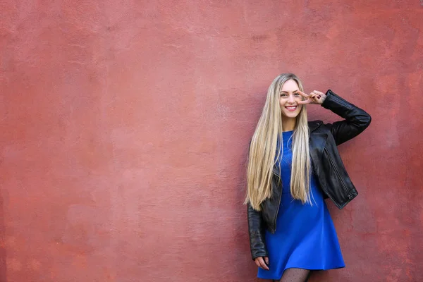 Schöne junge Frau im Freien in der Nähe der Grunge-Wand — Stockfoto