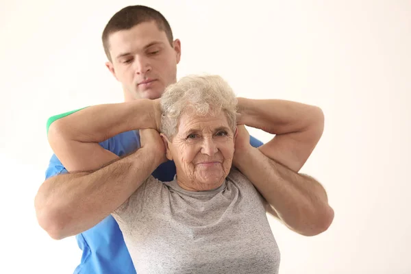 Sjukgymnast som arbetar med äldre patienter — Stockfoto