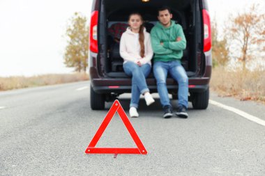 Araba ve arka plan üzerinde çift ile yolda trafik uyarı işaretleri