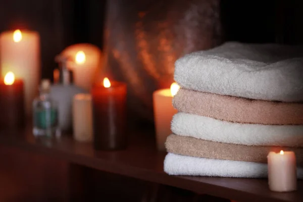 Svíčky s ručníky na dřevěný stůl — Stock fotografie