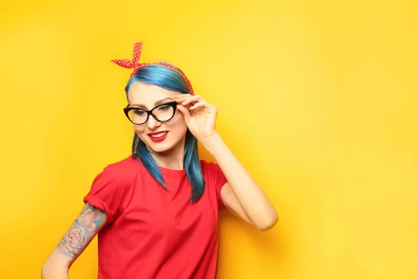 Bella giovane donna con capelli di colore elegante e tatuaggio su sfondo giallo — Foto Stock