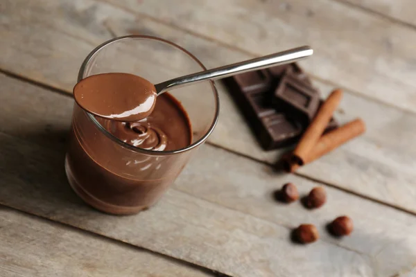 Μους σοκολάτα στο ποτήρι με κουτάλι σε φόντο ξύλινη — Φωτογραφία Αρχείου