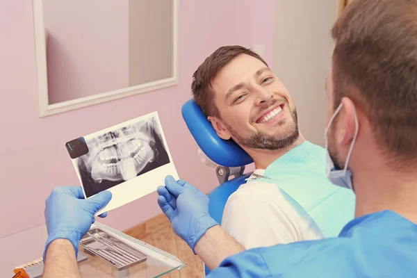 Patrząc Zdjęcie Rentgenowskie Zębów Młody Człowiek Dentysta — Zdjęcie stockowe