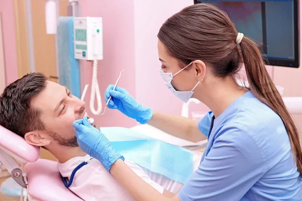 Стоматолог, осматривающий зубы пациентов — стоковое фото