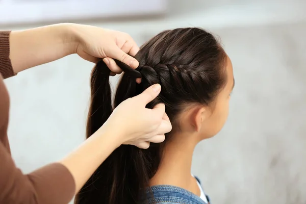 Жінка робить волосся своєї дочки — стокове фото