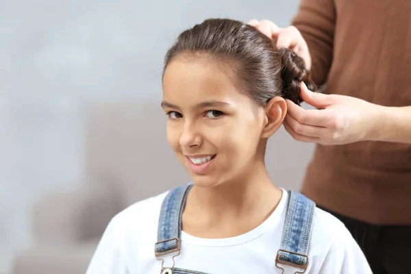 Frau macht Haare ihrer Tochter — Stockfoto