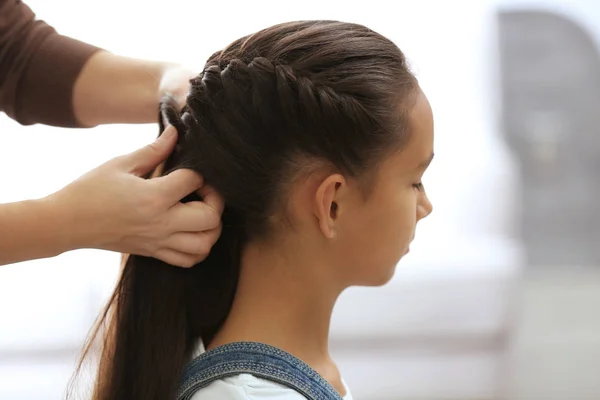 Mulher fazendo cabelo de sua filha — Fotografia de Stock