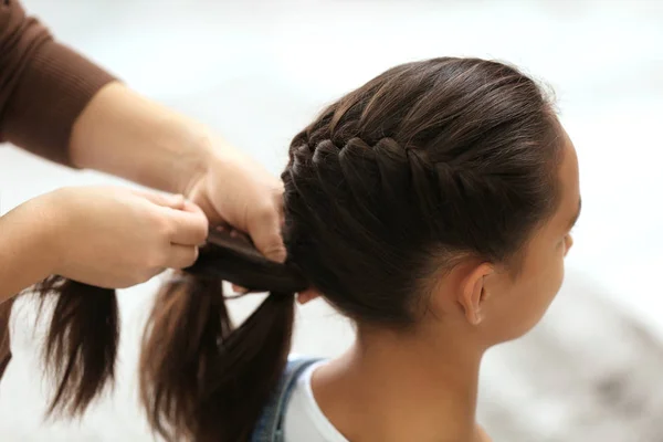 Mulher fazendo cabelo de sua filha — Fotografia de Stock
