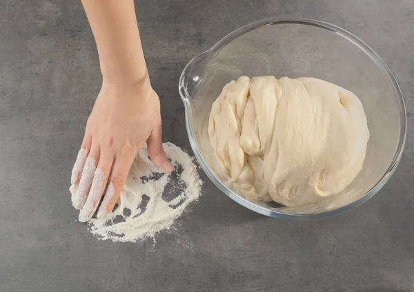 Женская рука и сырое тесто — стоковое фото