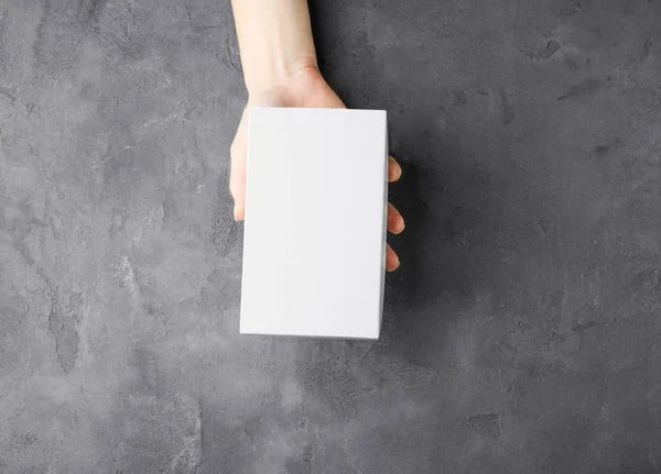 Mano femenina con caja blanca — Foto de Stock